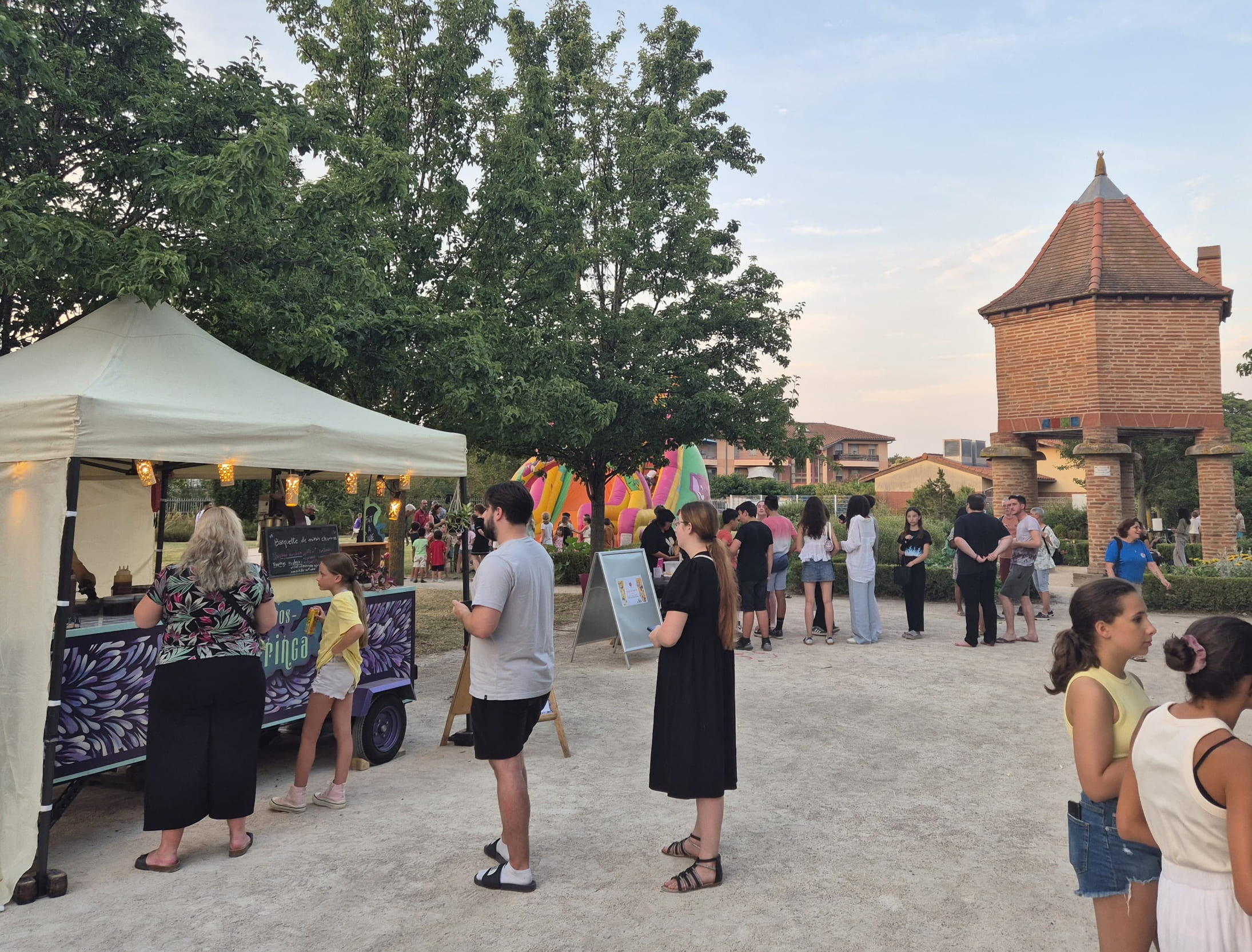 Le stand Churringa apporte une touche de douceur à la fête du village, proposant des confections sucrées aux petits et grands dans une ambiance de fin de journée ensoleillée.